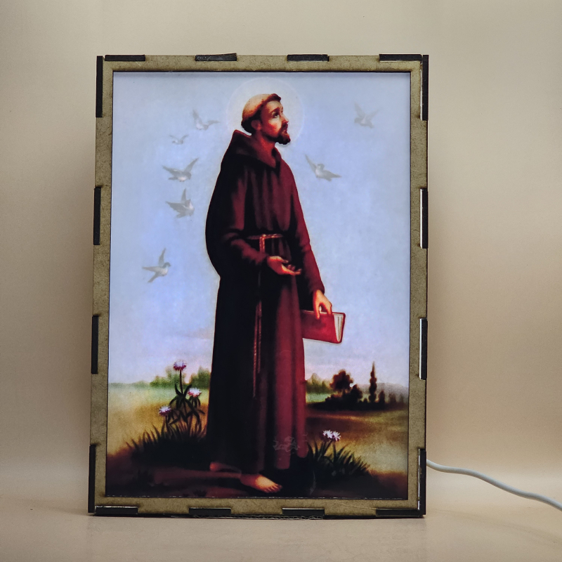 Lámpara con doble imagen  (San Francisco de Asis), vista encendida, con luz ambiente, donde se revela la ilustración completa al encender la luz LED.