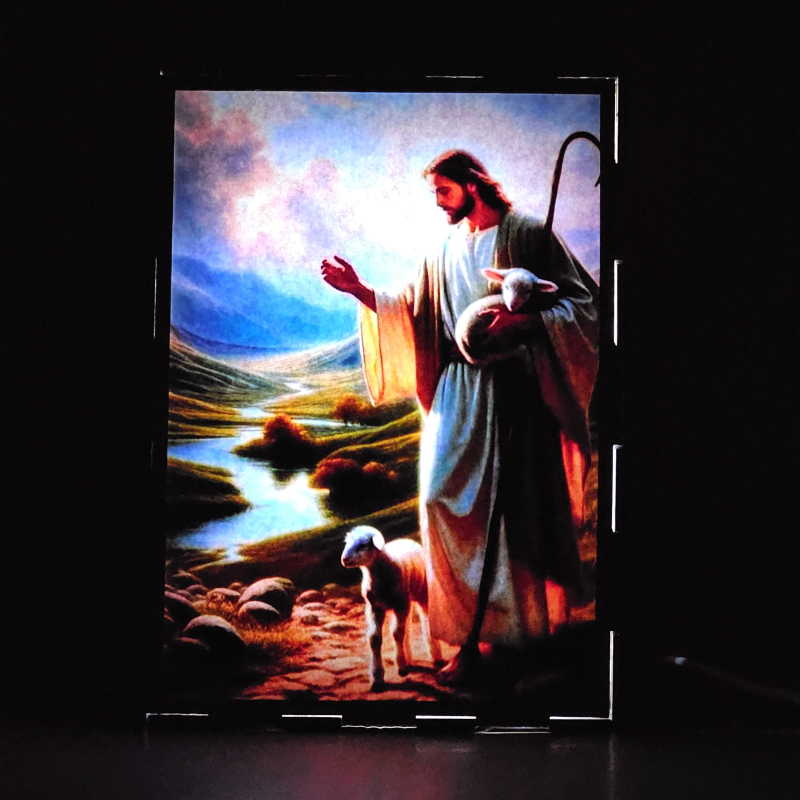 Lámpara con doble imagen  (Jesucristo buen pastor), vista encendida, donde se revela la ilustración completa al encender la luz LED.