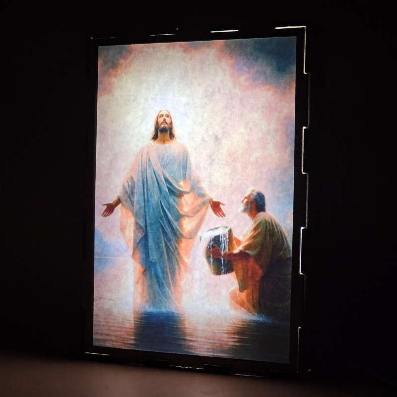 Lámpara con doble imagen el Primer misterio luminoso El Bautismo de Jesús en el Jordán (Nuestro Señor Jesucristo, San Juan Bautista), vista encendida, donde se revela la ilustración completa al encender la luz LED.