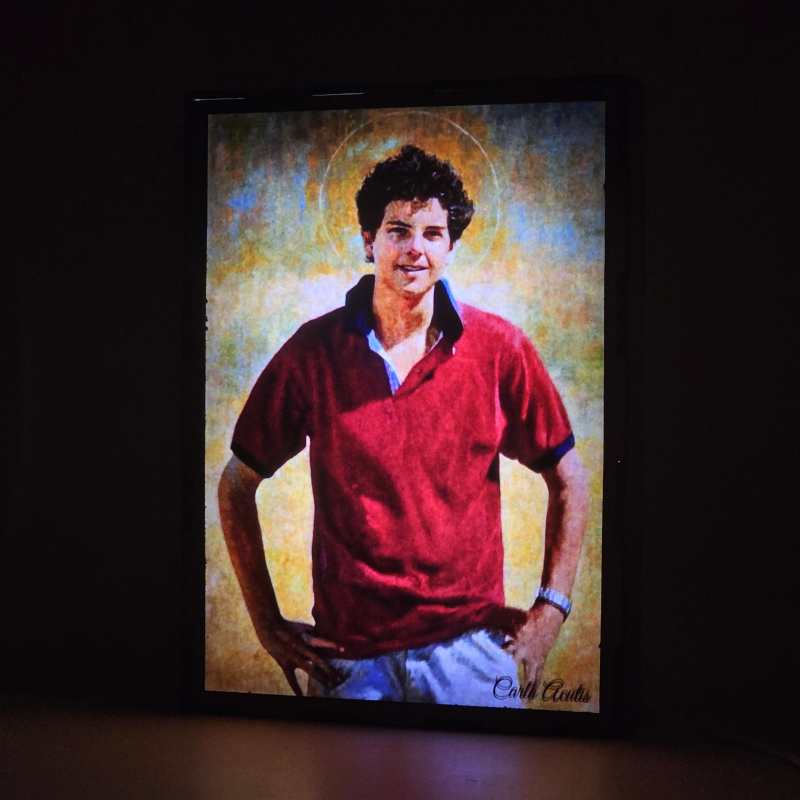 Lámpara con doble imagen  (Carlo Acutis), vista encendida, donde se revela la ilustración completa al encender la luz LED.