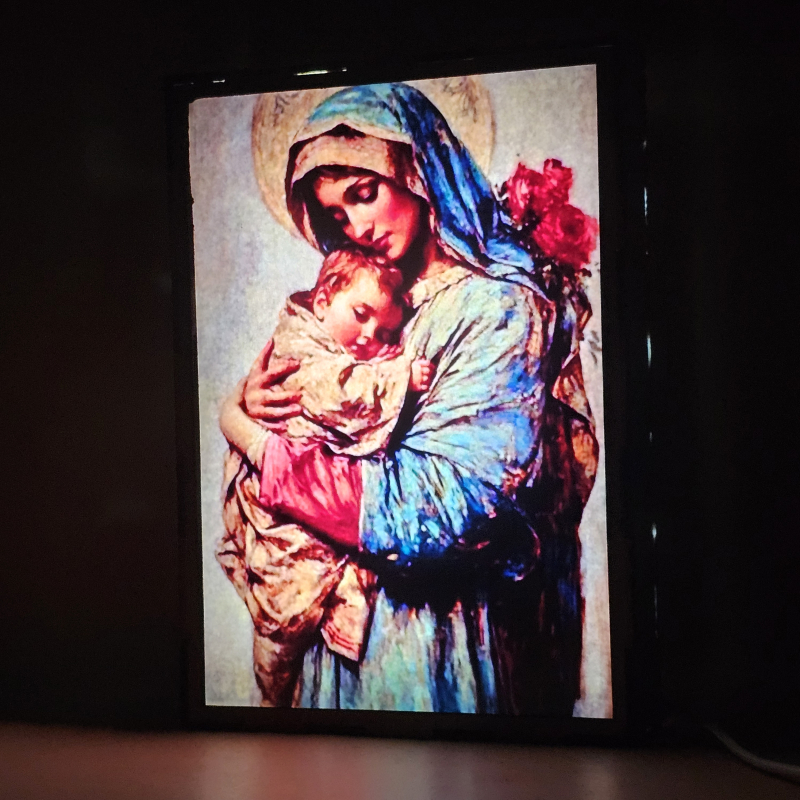 Lámpara con doble imagen  (La Virgen María, El niño Jesús), vista encendida, donde se revela la ilustración completa al encender la luz LED.