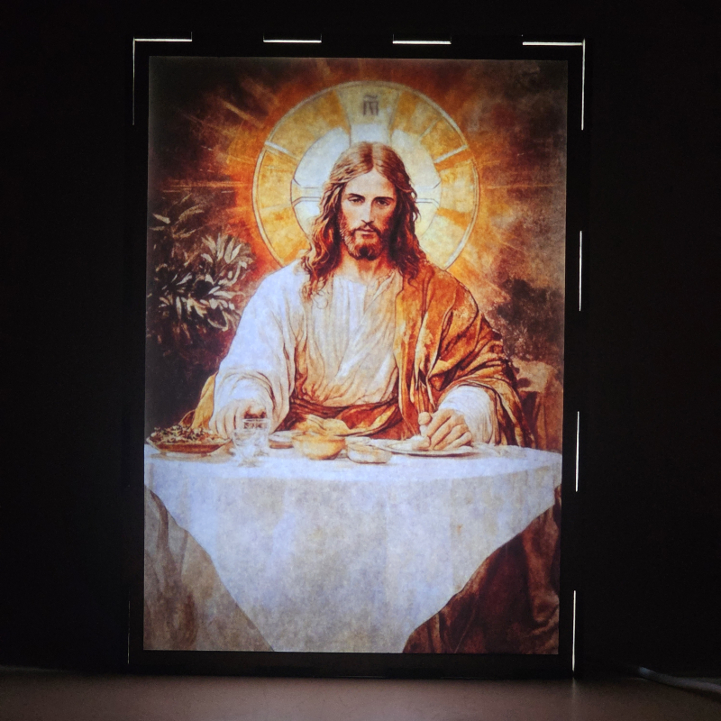 Lámpara con doble imagen el Quinto misterio luminoso La Institución de la Eucaristía (Nuestro Señor Jesucristo), vista encendida, donde se revela la ilustración completa al encender la luz LED.