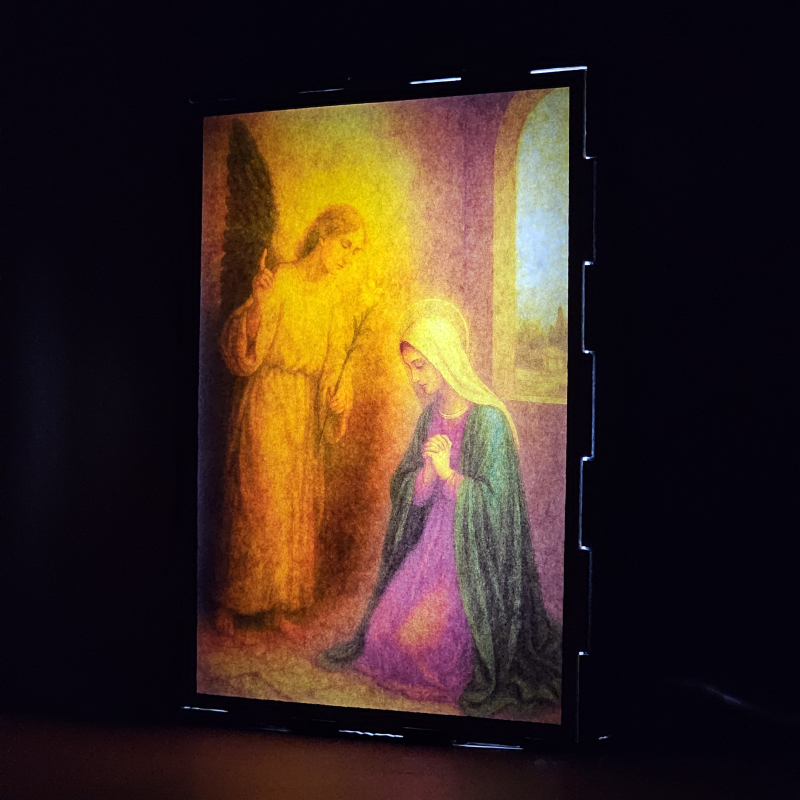 Lámpara con doble imagen el Primer misterio gosozo La Anunciación del Ángel a la Virgen María (), vista encendida, donde se revela la ilustración completa al encender la luz LED.