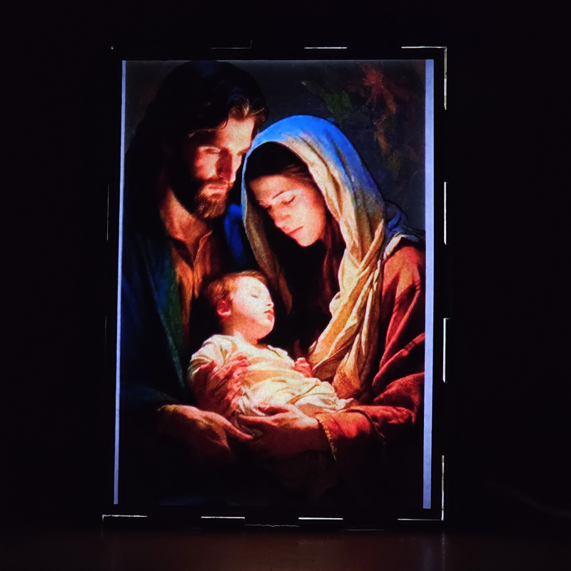Lámpara con doble imagen  (San José, La Virgen María, El niño Jesús), vista encendida, donde se revela la ilustración completa al encender la luz LED.