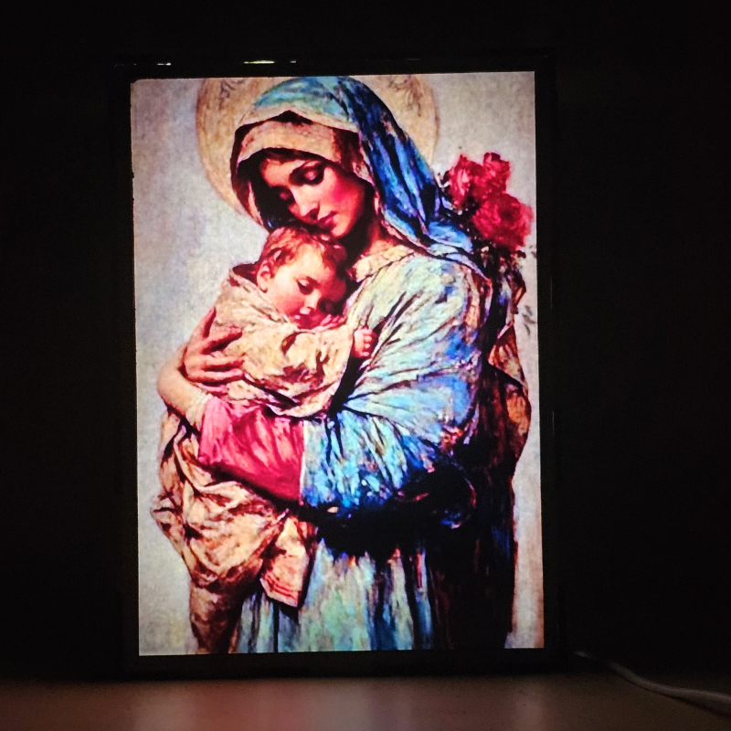 Lámpara con doble imagen  (La Virgen María, El niño Jesús), vista encendida, donde se revela la ilustración completa al encender la luz LED.