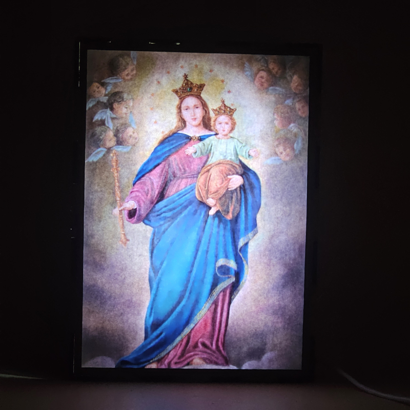 Lámpara con doble imagen  (Virgen María Auxiliadora), vista encendida, donde se revela la ilustración completa al encender la luz LED.