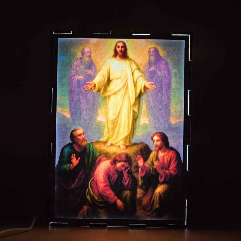 Lámpara con doble imagen el Cuarto misterio luminoso La Transfiguración del Señor (Nuestro Señor Jesucristo, El apostol Juan, El apostol Pedro, El apostol Santiago, El profeta Elías, Moises), vista encendida, donde se revela la ilustración completa al encender la luz LED.