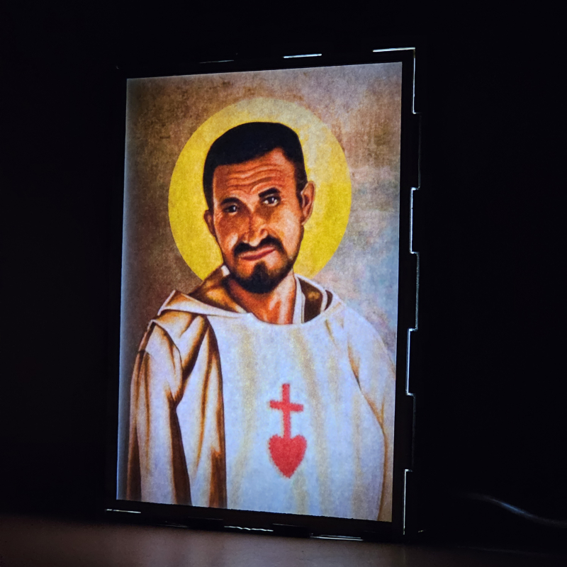 Lámpara con doble imagen  (Carlos de Foucauld), vista encendida, donde se revela la ilustración completa al encender la luz LED.