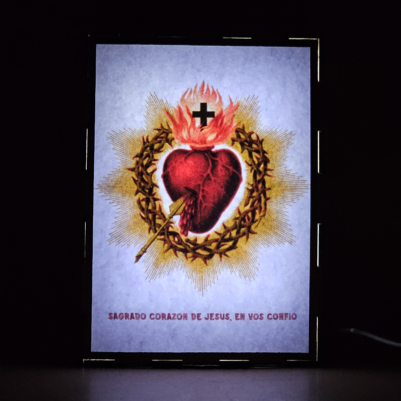 Lámpara con doble imagen  (Sagrado Corazón de Jesús), vista encendida, donde se revela la ilustración completa al encender la luz LED.