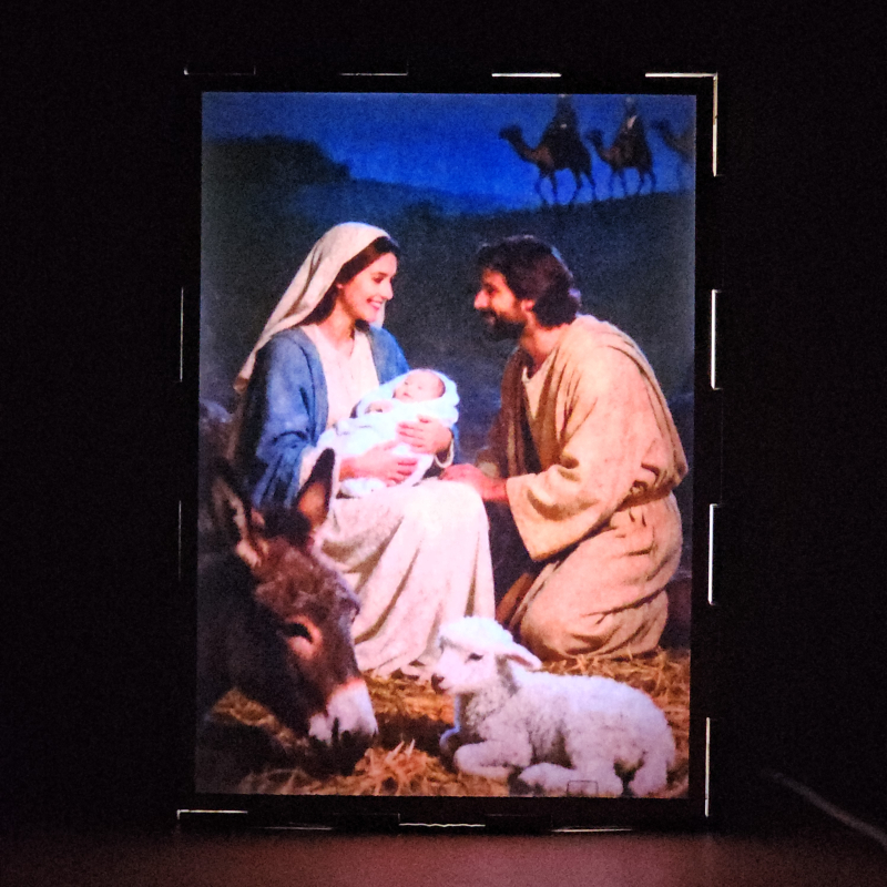 Lámpara con doble imagen el Tercer misterio gosozo El Nacimiento del Hijo de Dios (San José, La Virgen María, El niño Jesús), vista encendida, donde se revela la ilustración completa al encender la luz LED.
