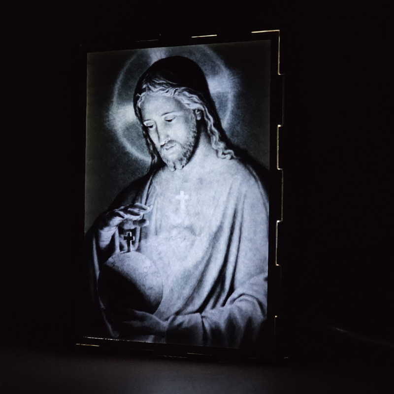 Lámpara con doble imagen  (Sagrado Corazón de Jesús), vista encendida, donde se revela la ilustración completa al encender la luz LED.