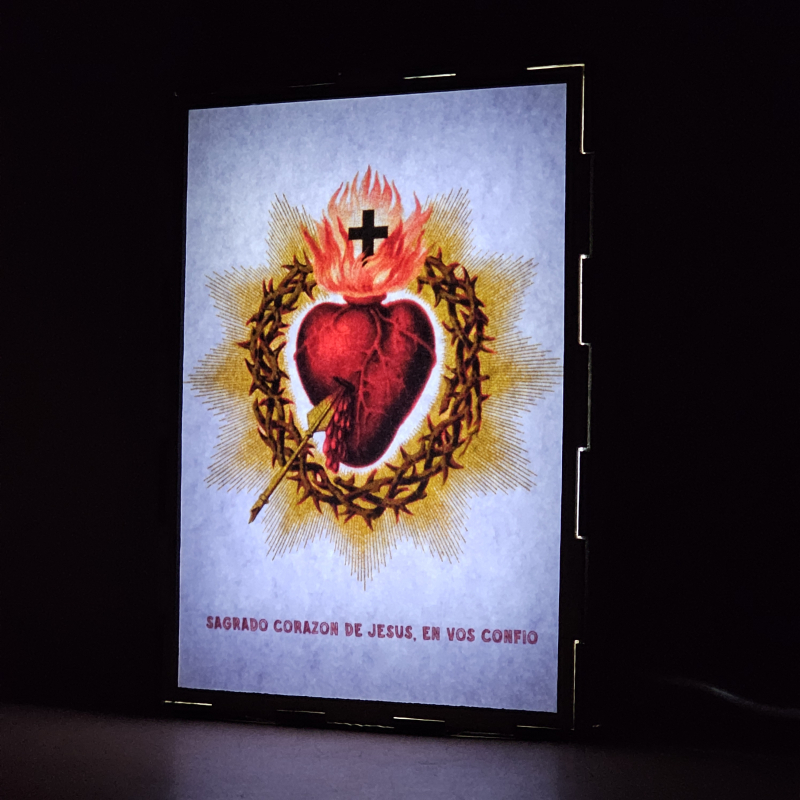 Lámpara con doble imagen  (Sagrado Corazón de Jesús), vista encendida, donde se revela la ilustración completa al encender la luz LED.