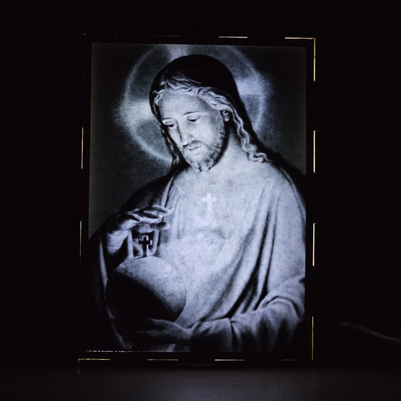 Lámpara con doble imagen  (Sagrado Corazón de Jesús), vista encendida, donde se revela la ilustración completa al encender la luz LED.