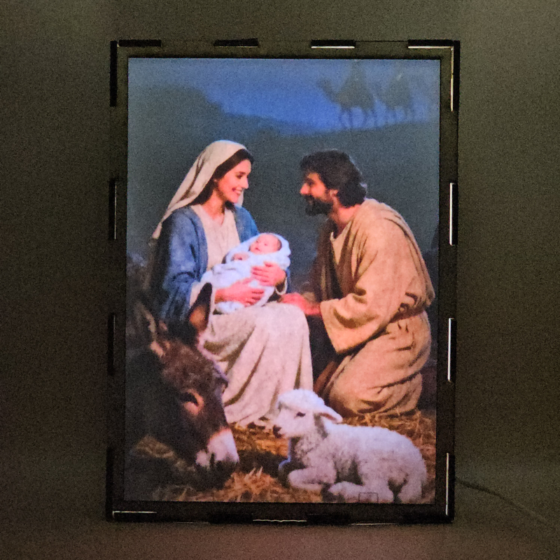 Lámpara con doble imagen el Tercer misterio gosozo El Nacimiento del Hijo de Dios (San José, La Virgen María, El niño Jesús), vista encendida, con luz ambiente, donde se revela la ilustración completa al encender la luz LED.