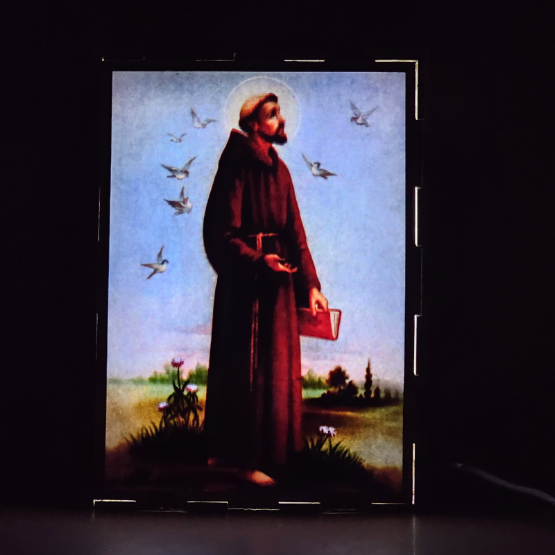 Lámpara con doble imagen  (San Francisco de Asis), vista encendida, donde se revela la ilustración completa al encender la luz LED.
