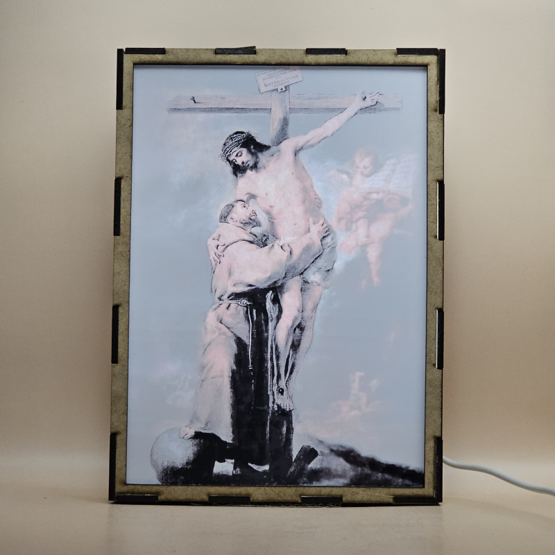 Lámpara con doble imagen  (San Francisco de Asis), vista encendida, con luz ambiente, donde se revela la ilustración completa al encender la luz LED.