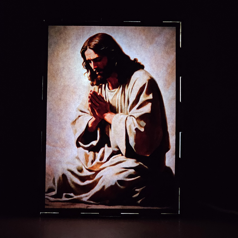 Lámpara con doble imagen el Primer Misterio Doloroso La oración de Jesus en el Huerto (), vista encendida, donde se revela la ilustración completa al encender la luz LED.