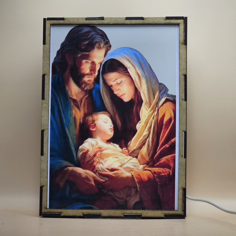 Lámpara con doble imagen  (San José, La Virgen María, El niño Jesús), vista encendida, con luz ambiente, donde se revela la ilustración completa al encender la luz LED.