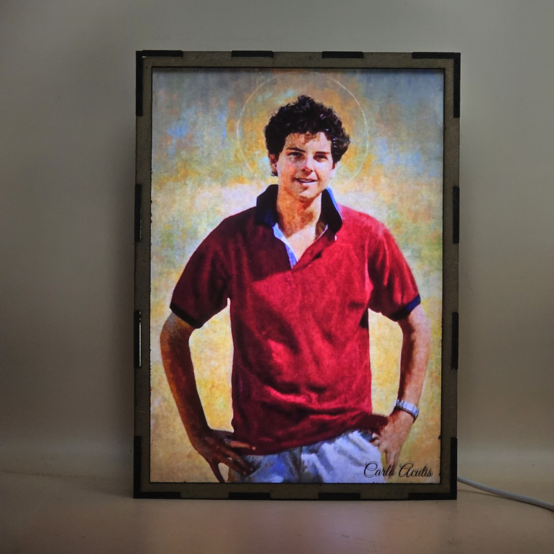 Lámpara con doble imagen  (Carlo Acutis), vista encendida, con luz ambiente, donde se revela la ilustración completa al encender la luz LED.