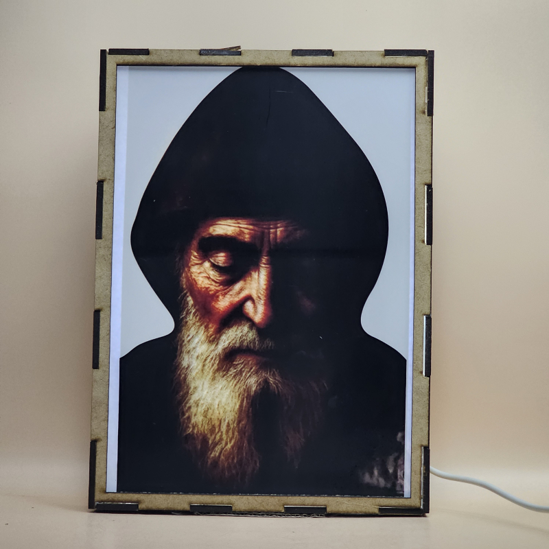 Lámpara con doble imagen  (San Charbel), vista encendida, con luz ambiente, donde se revela la ilustración completa al encender la luz LED.
