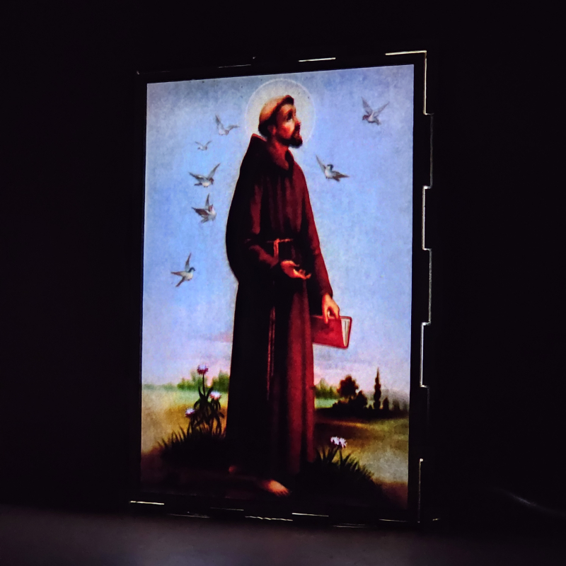Lámpara con doble imagen  (San Francisco de Asis), vista encendida, donde se revela la ilustración completa al encender la luz LED.