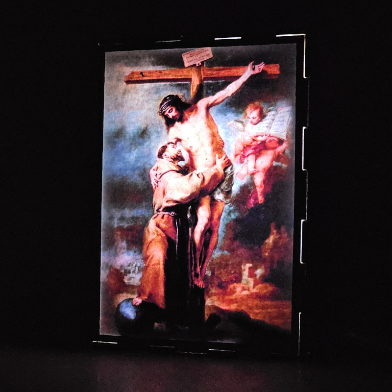 Lámpara con doble imagen  (San Francisco de Asis), vista encendida, donde se revela la ilustración completa al encender la luz LED.