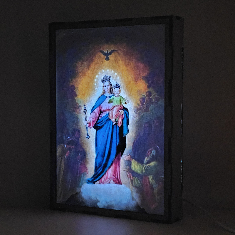 Lámpara con doble imagen  (Virgen María Auxiliadora), vista encendida, donde se revela la ilustración completa al encender la luz LED.