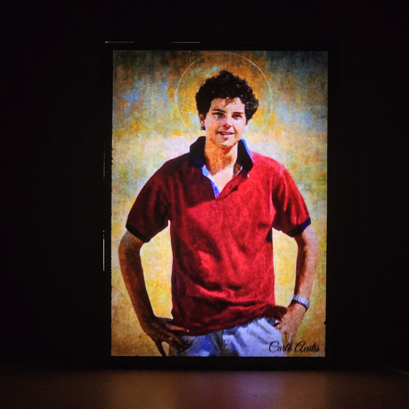 Lámpara con doble imagen  (Carlo Acutis), vista encendida, donde se revela la ilustración completa al encender la luz LED.