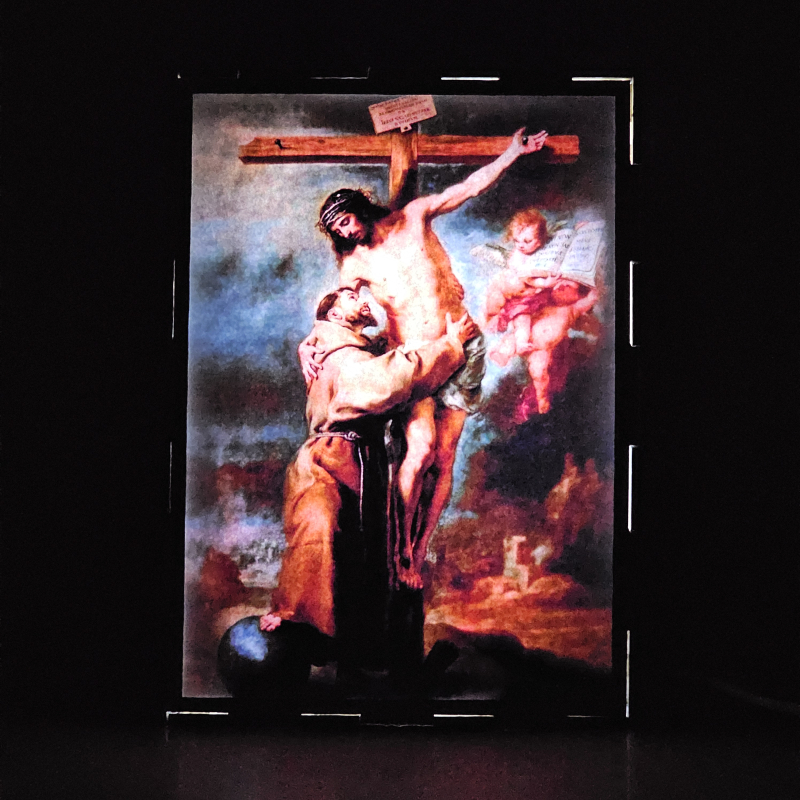 Lámpara con doble imagen  (San Francisco de Asis), vista encendida, donde se revela la ilustración completa al encender la luz LED.