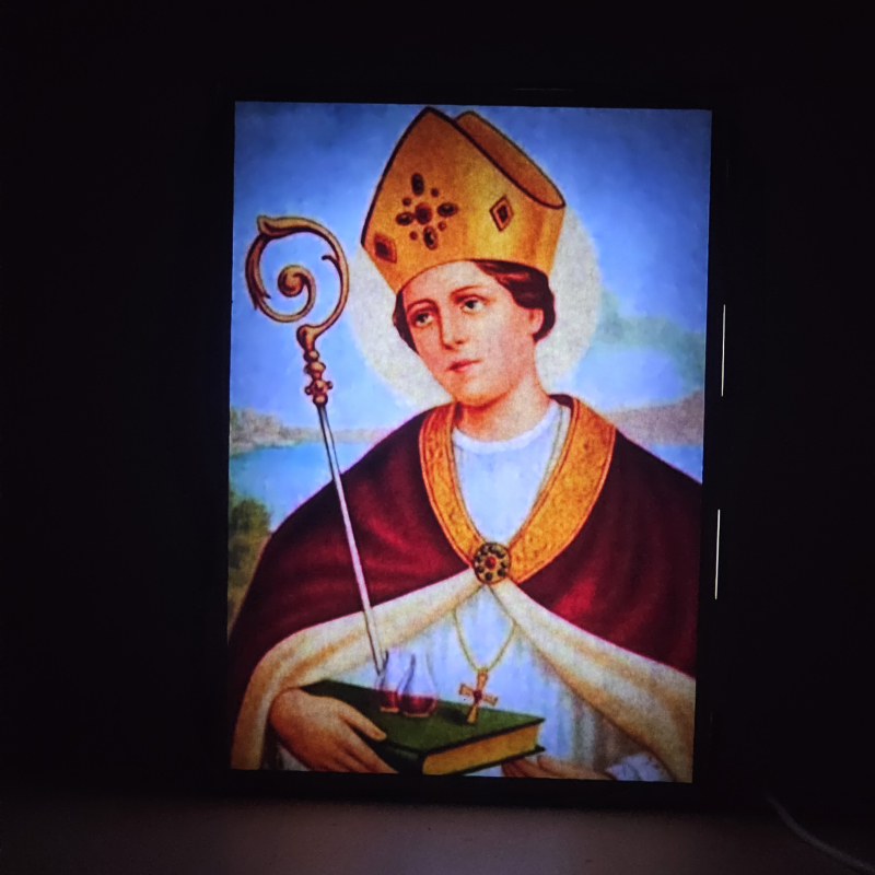 Lámpara con doble imagen  (San Genaro), vista encendida, donde se revela la ilustración completa al encender la luz LED.